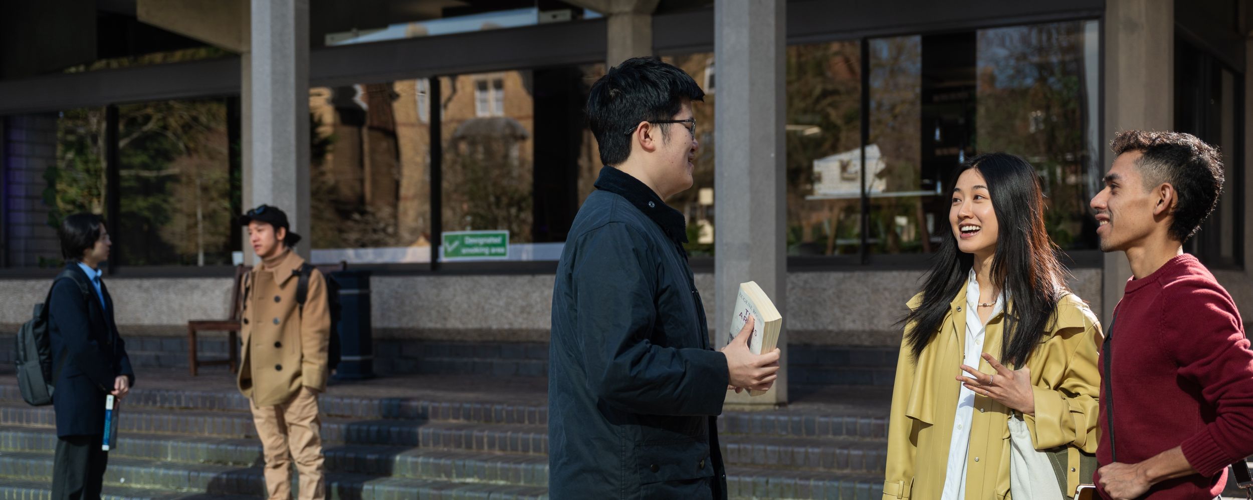 two groups of students standing outside college buildings 