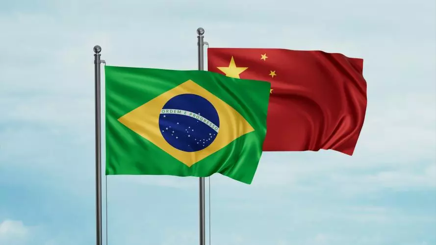 National flags of Brazil and China flying against background of blue sky