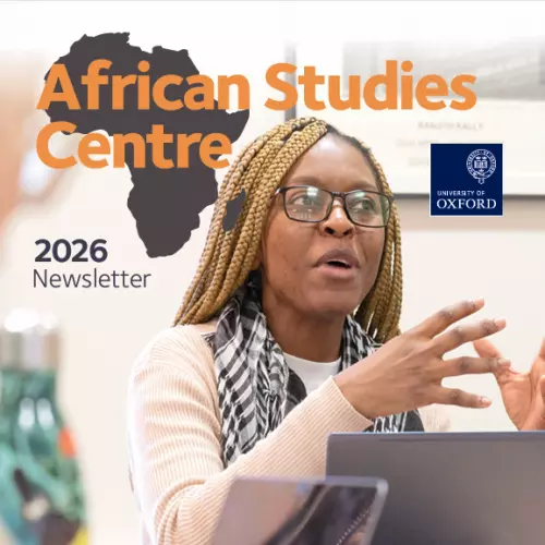 A student sat with a laptop in a seminar. She is gesturing and speaking to her classmates. Text above her head says: 'African Studies Centre, 2026 newsletter'