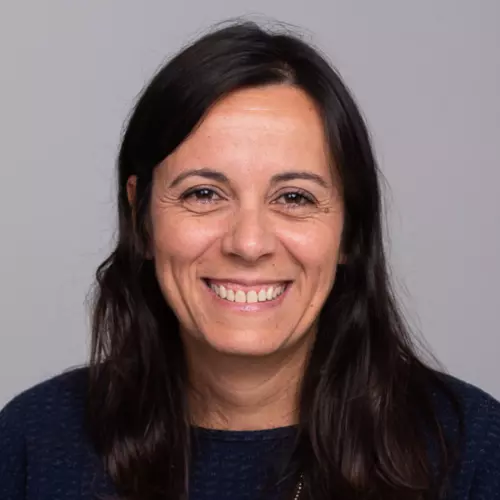 Francesca has long dark hair and is smiling at the camera. She's wearing a black jumper