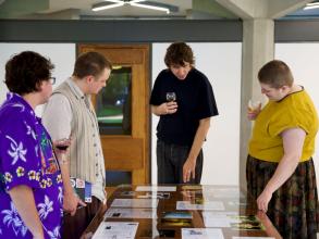People looking at documents in an exhibition display cabinet